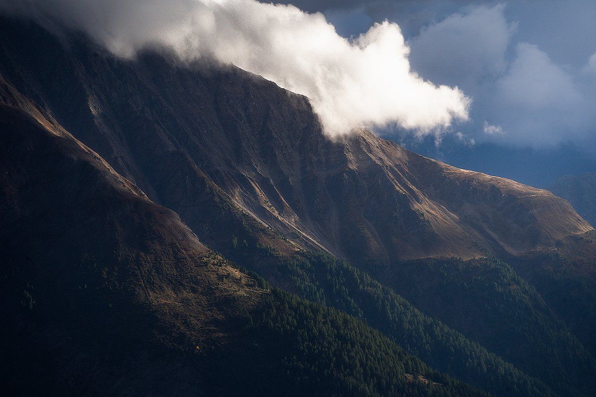 Markante Wolke umhüllt eine schweizer Bergkulisse, Schweiz