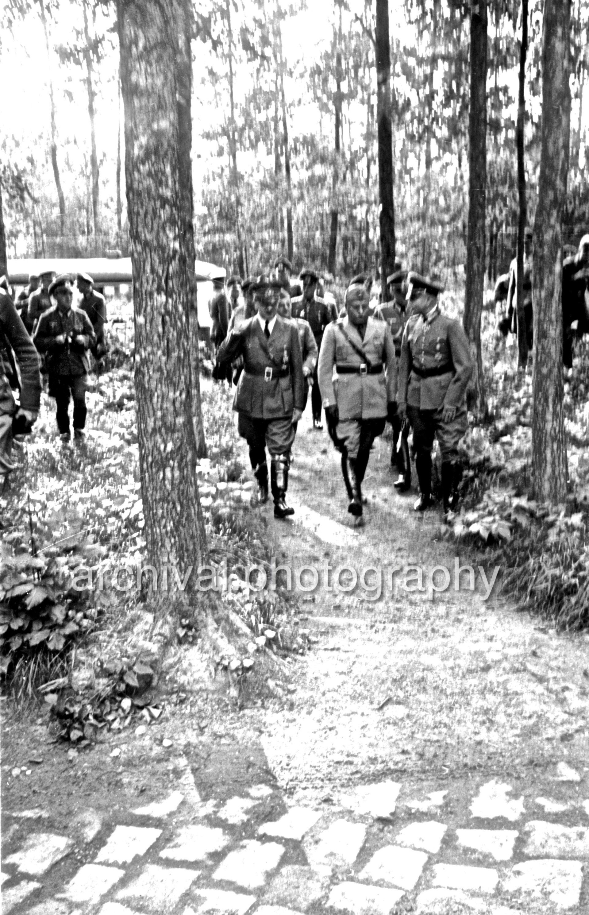 Hitler, Mussolini and SS Officers walking through forest - Nazi Adolf Hitler and the Italian 'Il Duce' Benito Mussolini on the train platform at the 'Wolfsschanze' Wolf's Lair headquarters at Rastenburg in East Prussia - Nazi Adolf Hitler and the Italian 'Il Duce' Benito Mussolini on the train platform at the 'Wolfsschanze' Wolf's Lair headquarters at Rastenburg in East Prussia