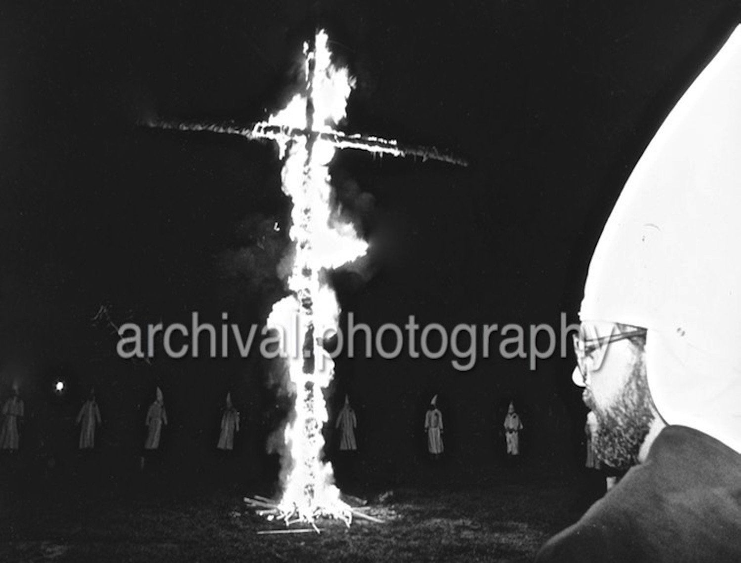 Ku Klux Klan - CROSS BURNING in a field WITH KLANSMAN IN FOREGROUND