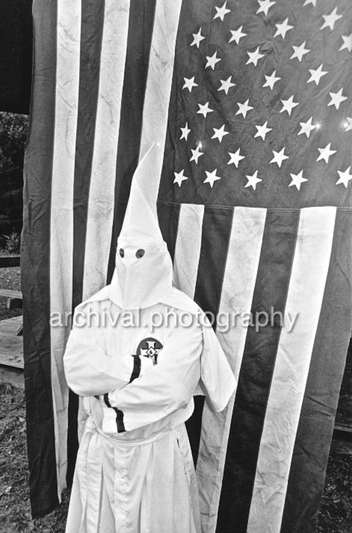 KKK member standing in front of American flag - Ku Klux Klan - KKK member IN FRONT OF US FLAG