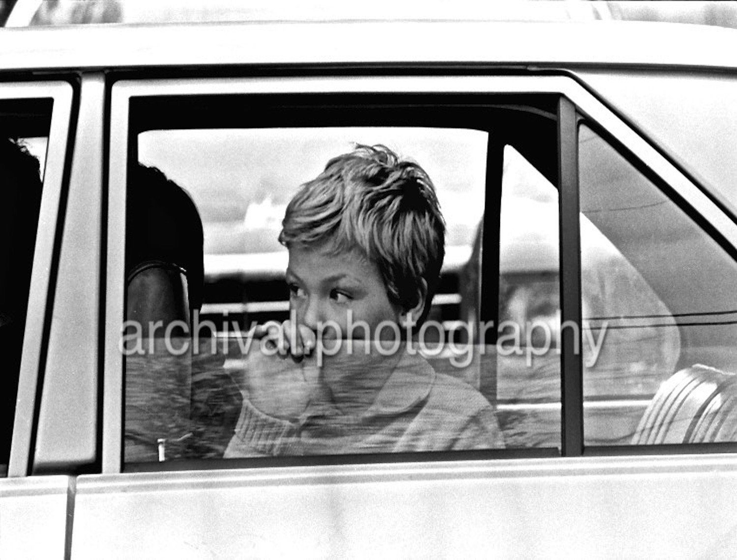 Child staring out window of car