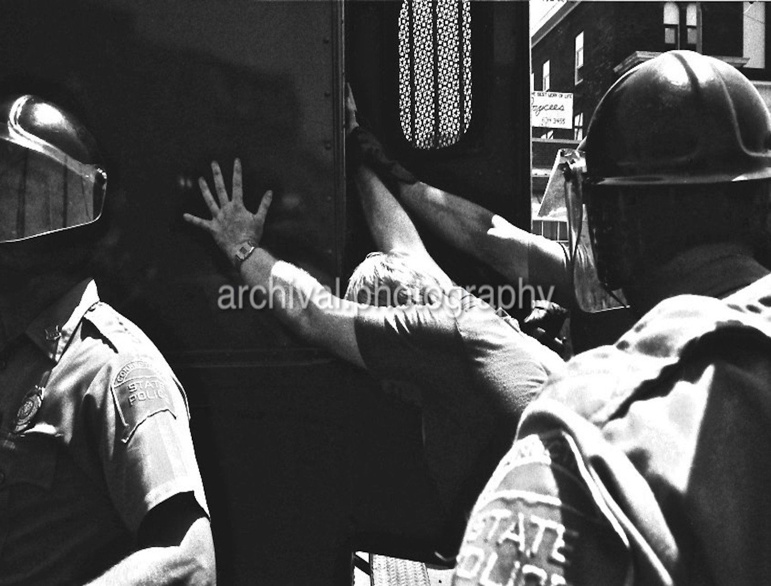 Man being pushed against van by police