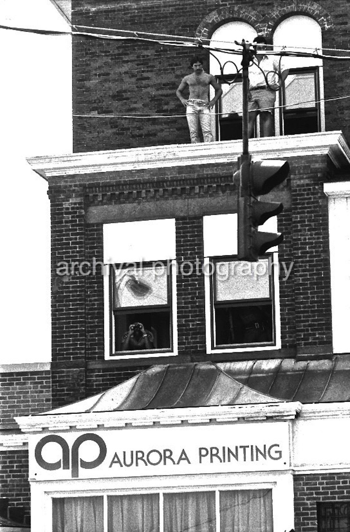 Two men standing on roof of building