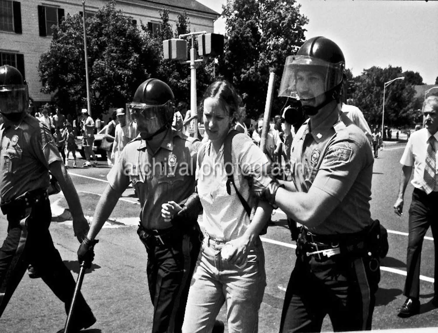 Woman being arrested by riot police