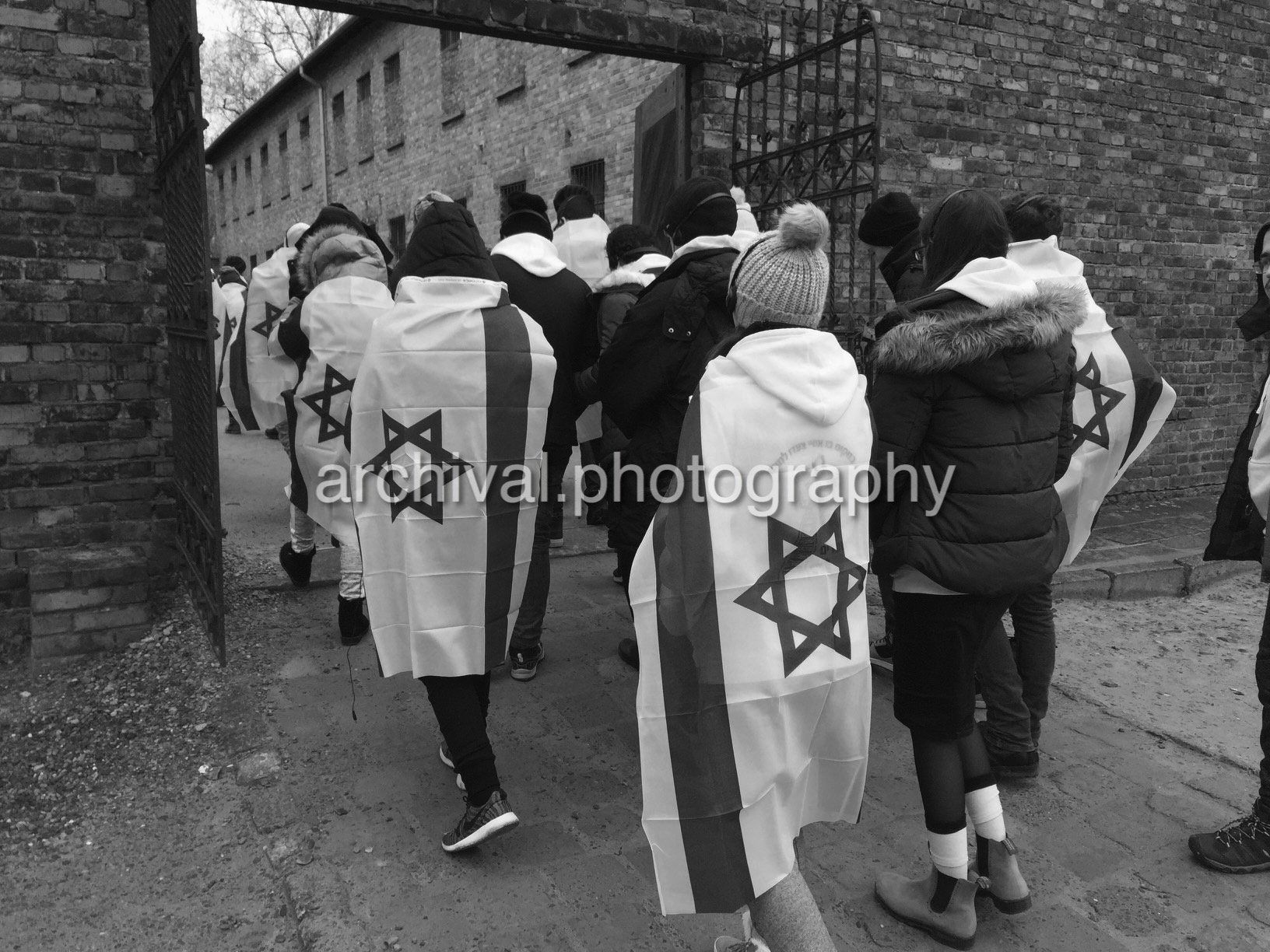 People visiting Auschwitz wrapped in Israeli flags - Auschwitz Concentration Camp -