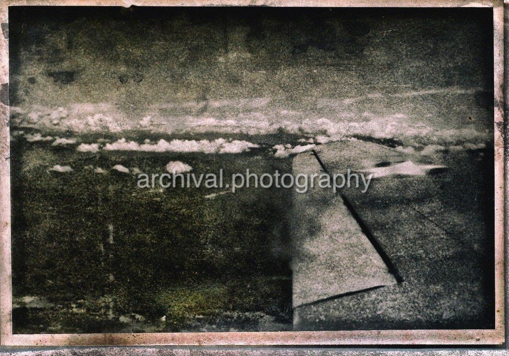 Image of US AIRCRAFT wing as it flies ABOVE CLOUDS