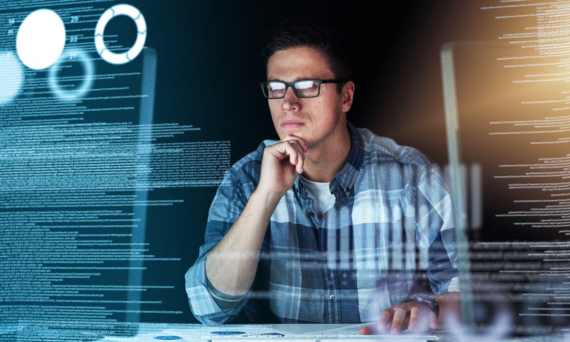 Ein Informatiker, welcher sehr konzentriert Code analysiert