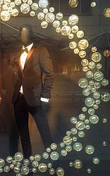 Ein stilvolles Schaufenster mit einer Herrenmodepuppe, umgeben von durchsichtigen Acrylkugeln. Die Kugeln sind kunstvoll angeordnet und verleihen der Präsentation eine moderne und ansprechende Atmosphäre. Diese kreative Dekoration zieht die Blicke auf sich und unterstreicht die Eleganz der Herrenmode. Perfekt für Modegeschäfte, um Kunden anzulocken und das Ambiente zu verschönern