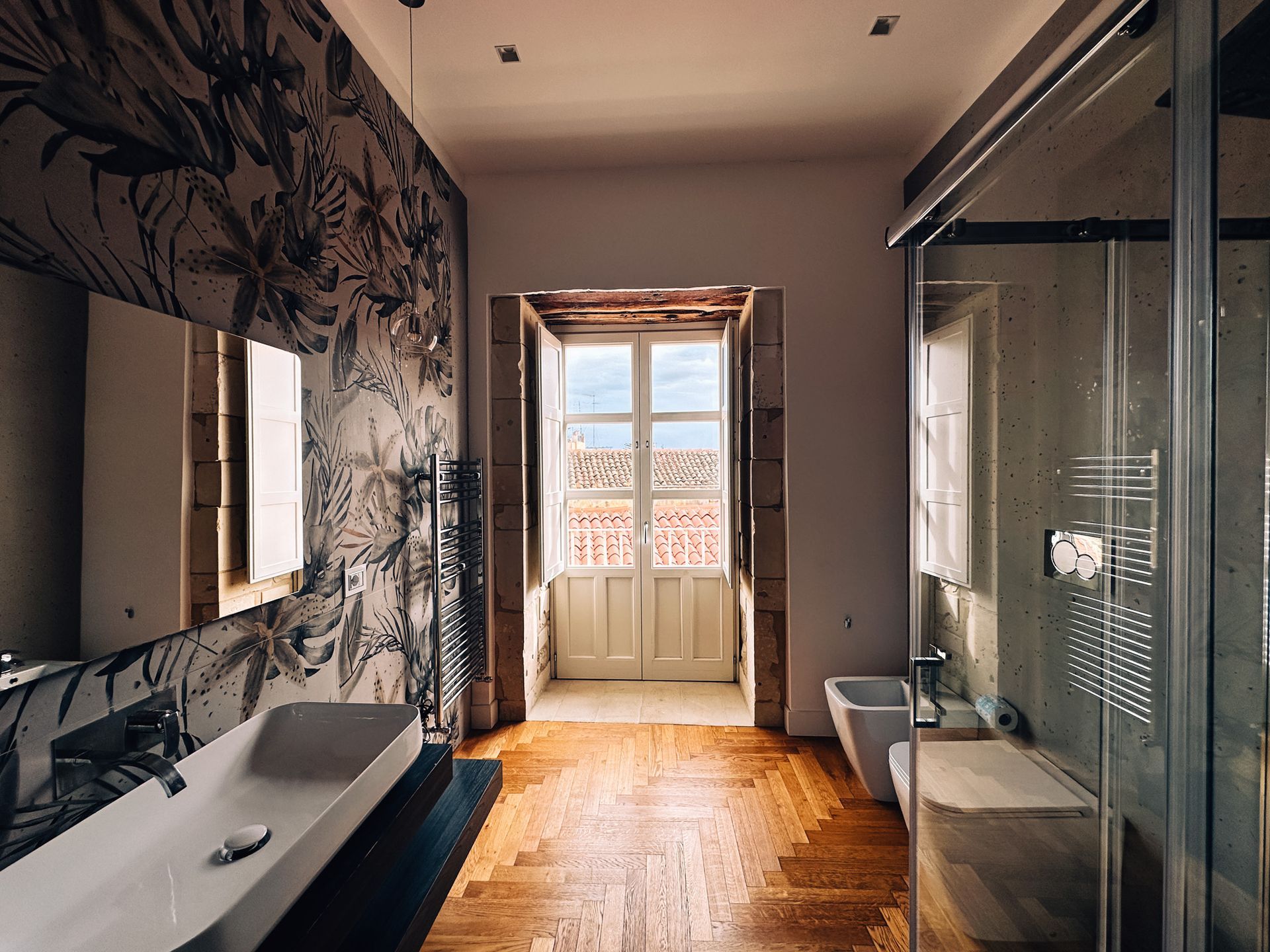 Bagno moderno con parete decorata e balcone.