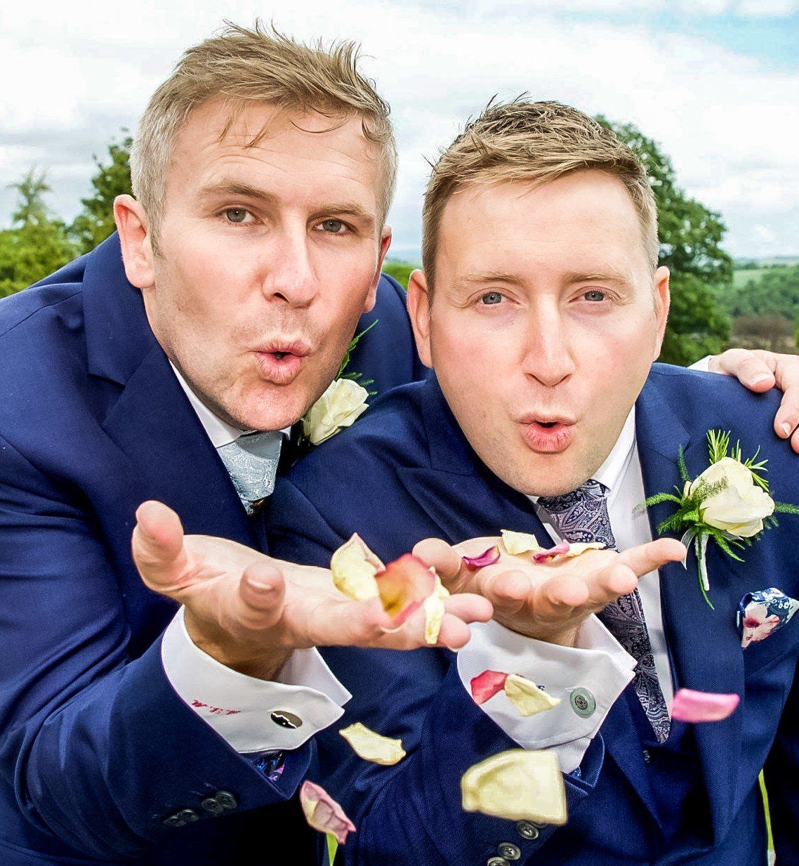 Two happy grooms show their pride with same-sex wedding suits from Adam James Bespoke tailoring. Style doesn't discriminate and neither do I