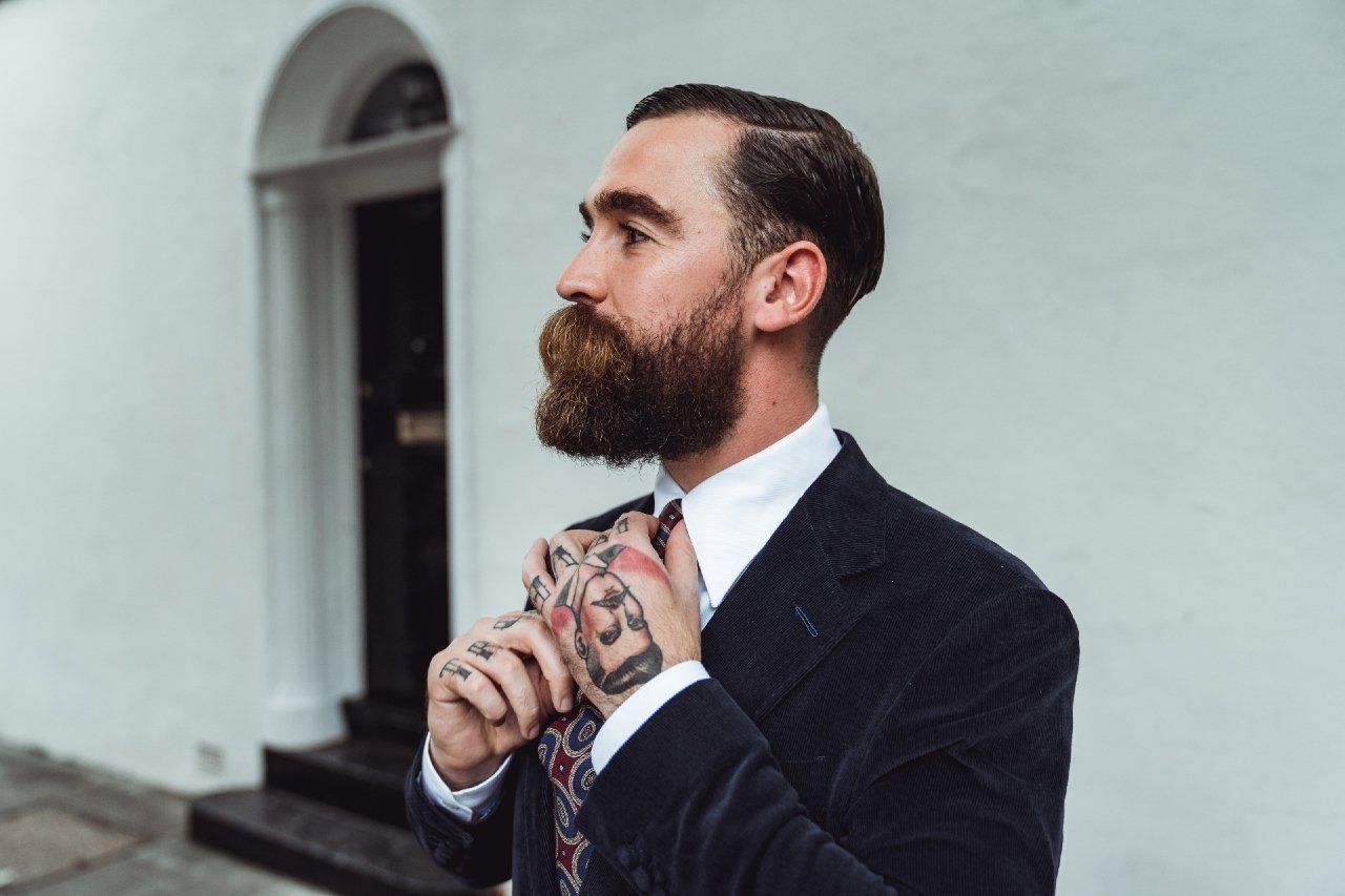 Adam Davies, founder and tailor of Adam James Bespoke, wears a crisp form-fitting dark blue suit