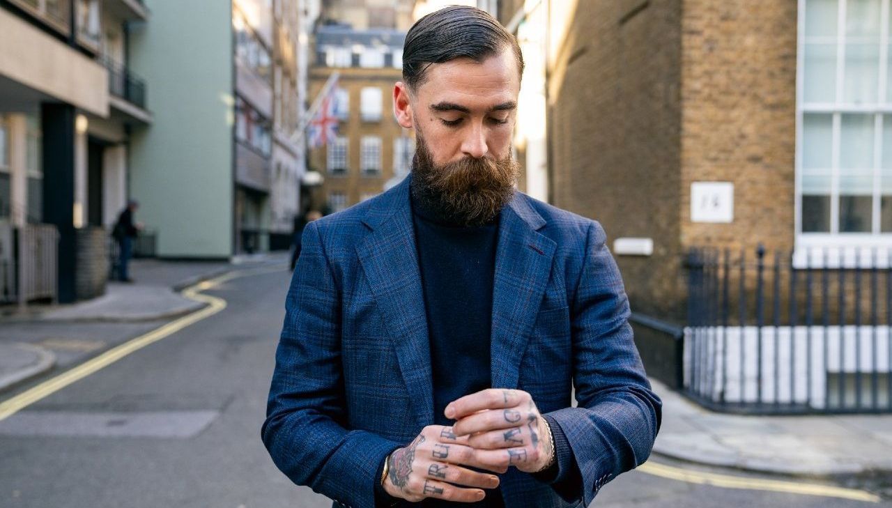 Adam Davies, founder of Adam James Bespoke, wears a stylish, ethical blue tailored suit