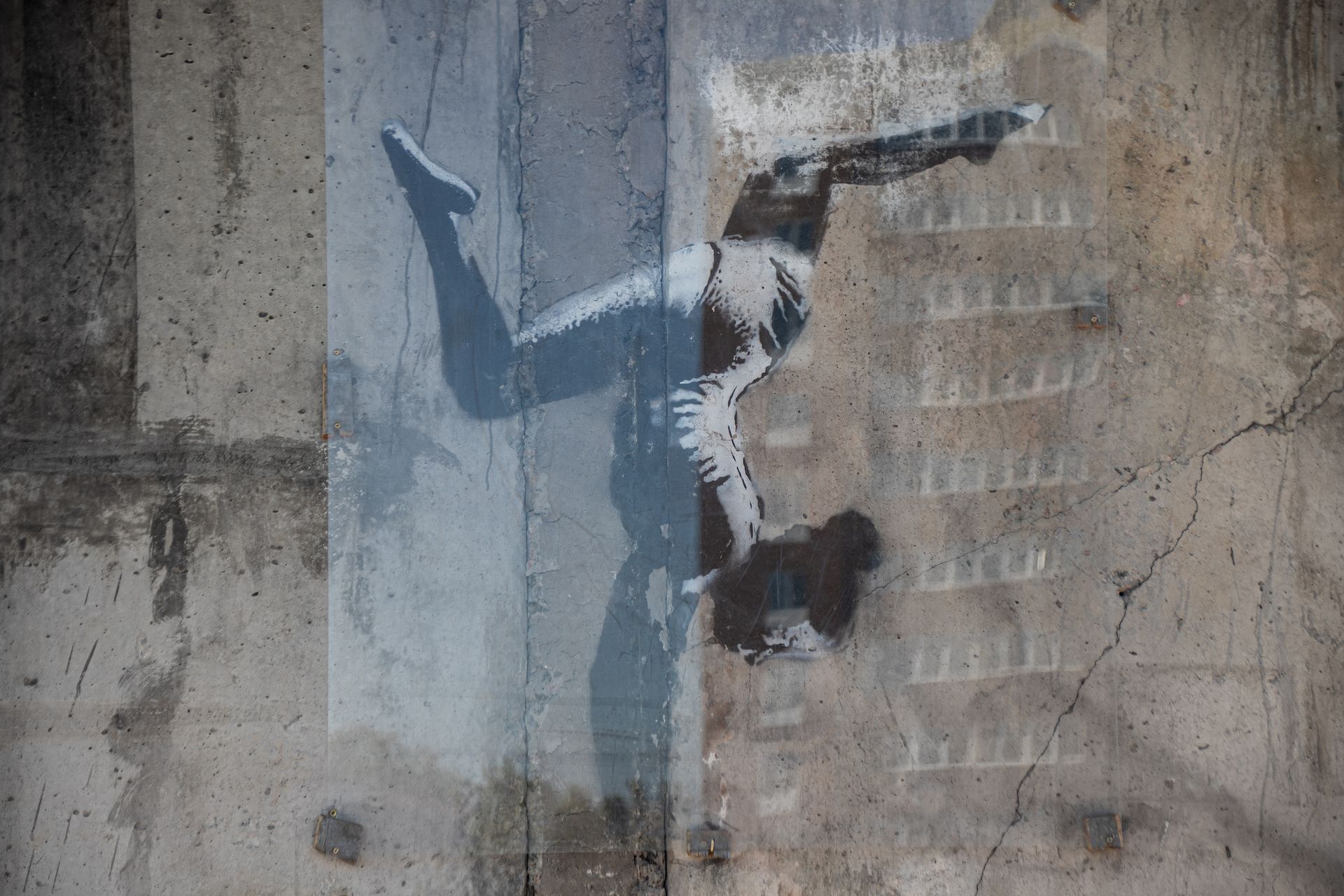 Banksy artwork of a gymnast on rubble, preserved behind glass in Borodianka, spring 2025