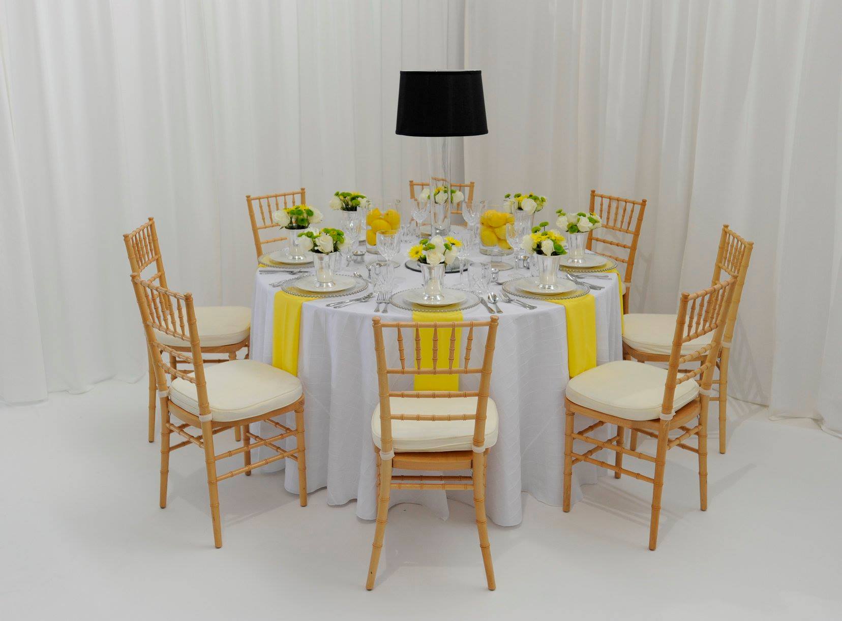 table arrangement concept with white & yellow fabrics, and wooden chairs