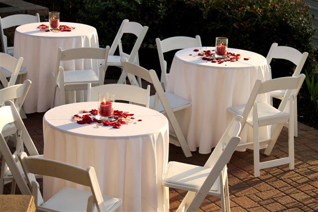 outdoor table arrangement concept with white fabrics and red rose petals