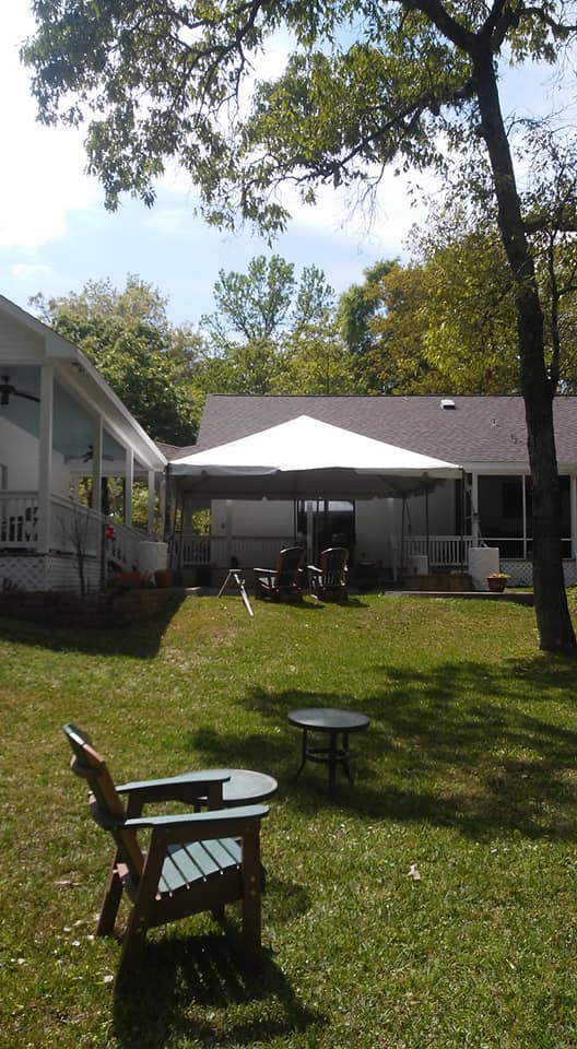 outdoor tent in a backyard with furniture in foreground