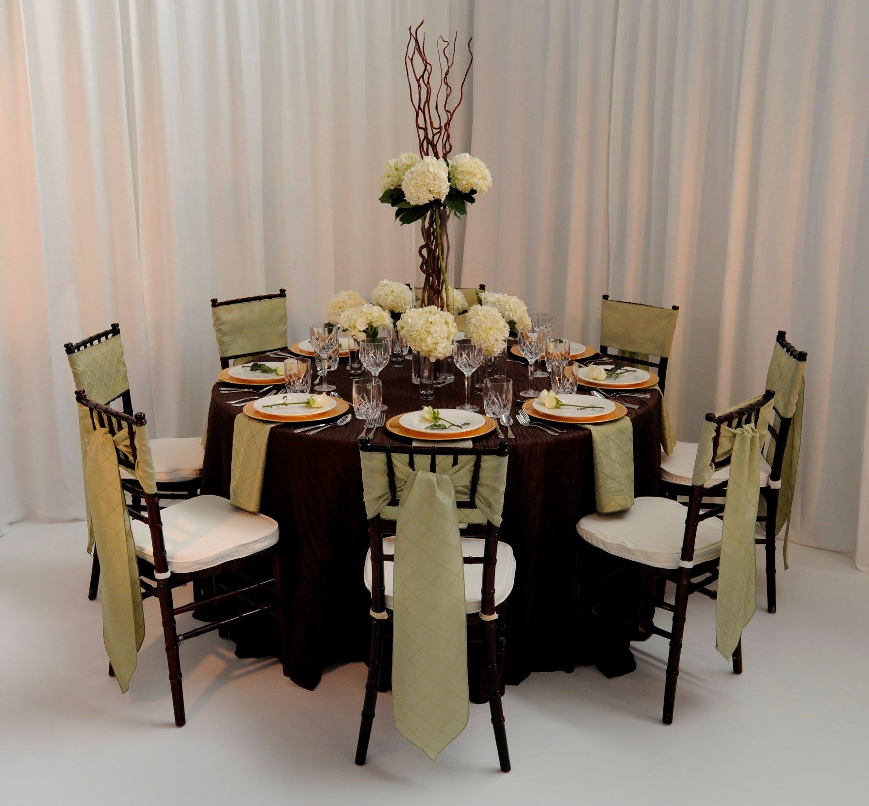 table arrangement with black chairs, yellow fabric accents, and yellow flowers