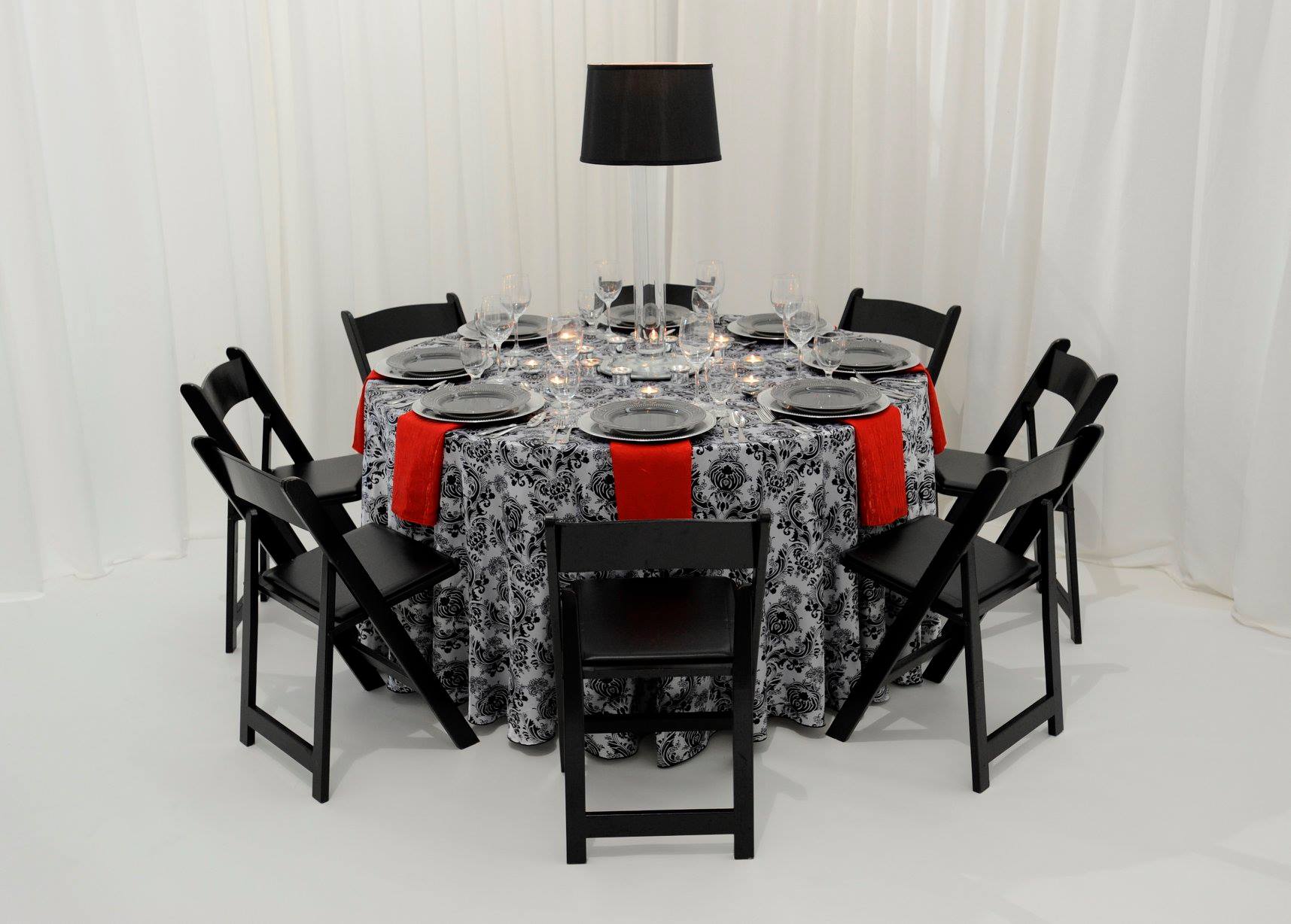 table arrangement concept in patterned black and white fabric with red napkin accents