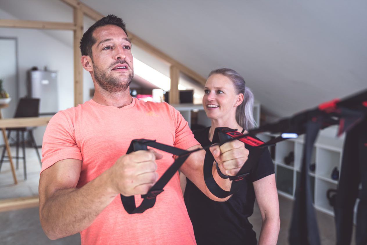 Kim zeigt einem Kunden Übungen für ein effektives Bodyworkout