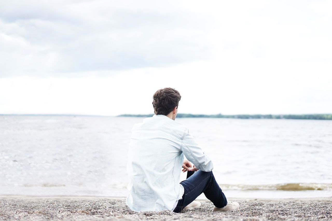 Ein einsamer Mann blickt aufs Meer.