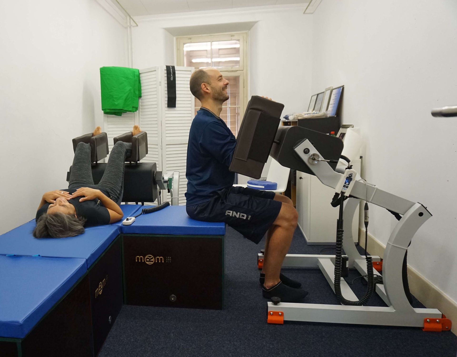 TERAPIA DE ONDA CINÉTICA Mujer y hombre realizando tratamientos con un equipo de rehabilitación muscular MRM Pro Sport.