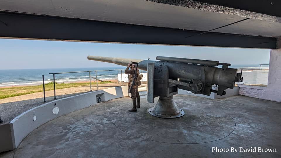 Soldier standing watch next to Blyth Battery Naval Guns