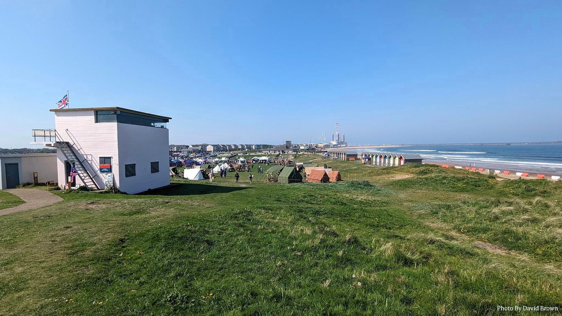 View of blyth Battery WWII observation tower with the reenactment and other organizations encampment below.