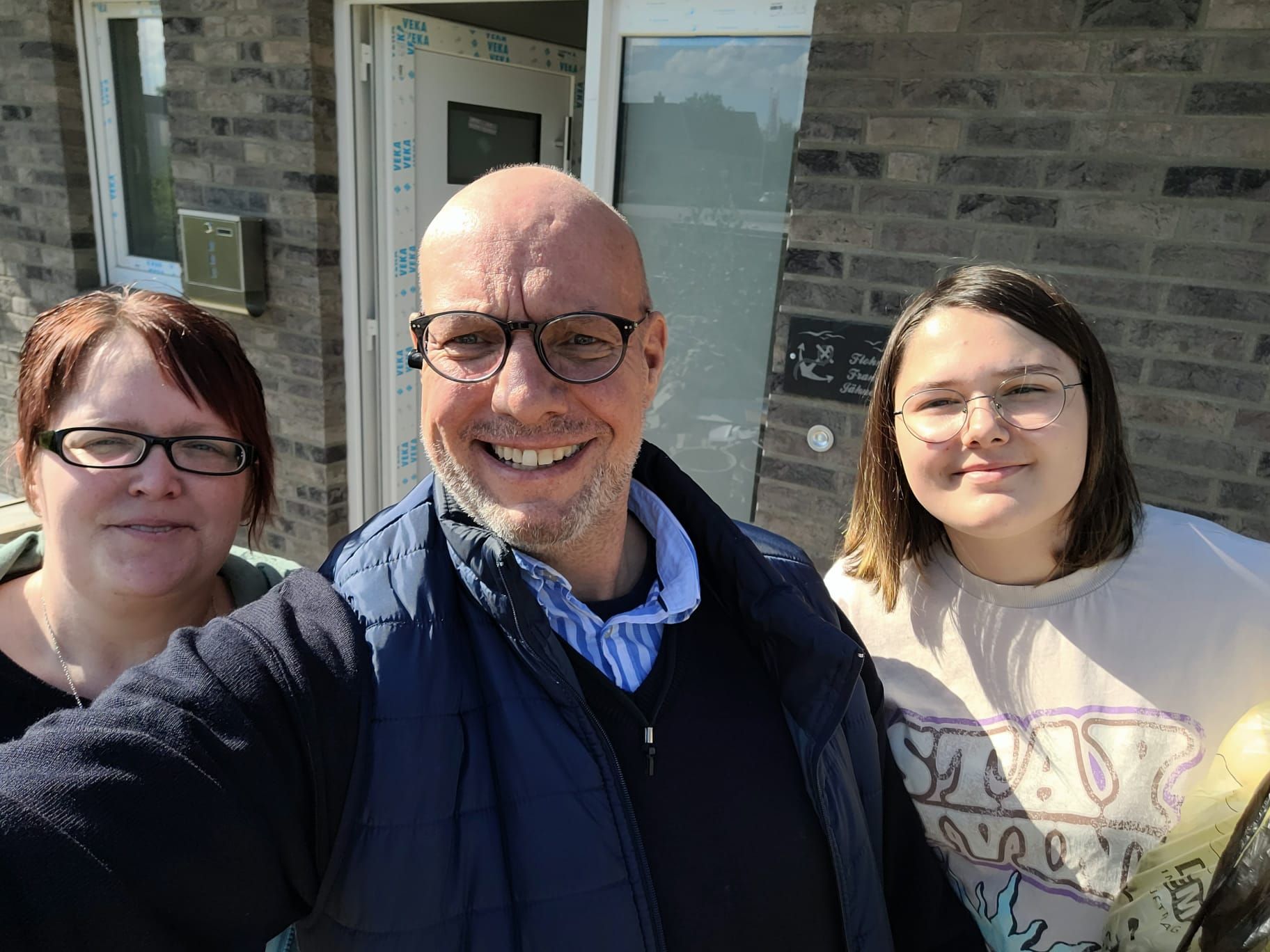 Unsere Angebote im Internet Personen mit Grundriss vor einem Haus