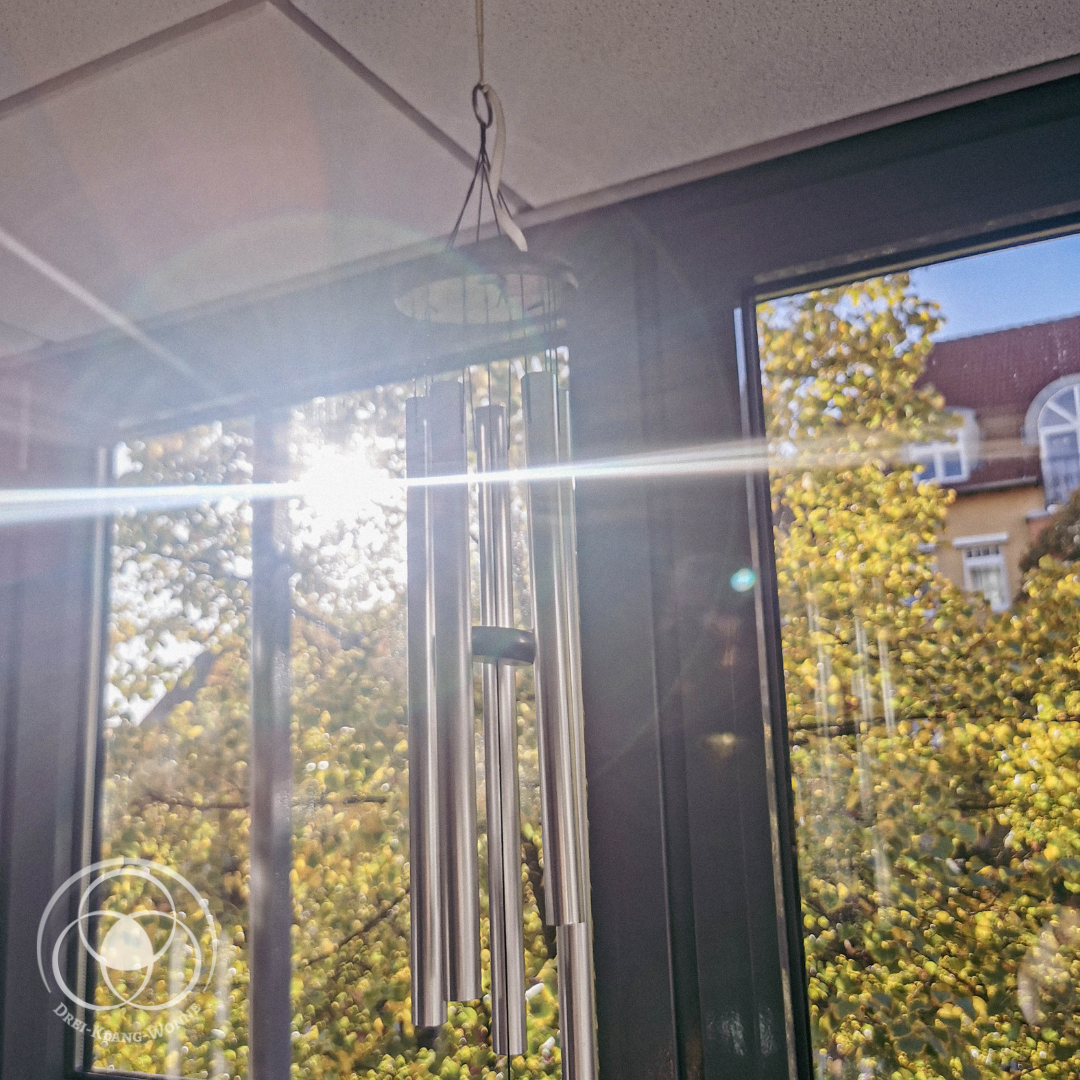 Helle, lichtdurchflutete Praxisräume, Windspiel im Fenster mit Sonnenstrahlen