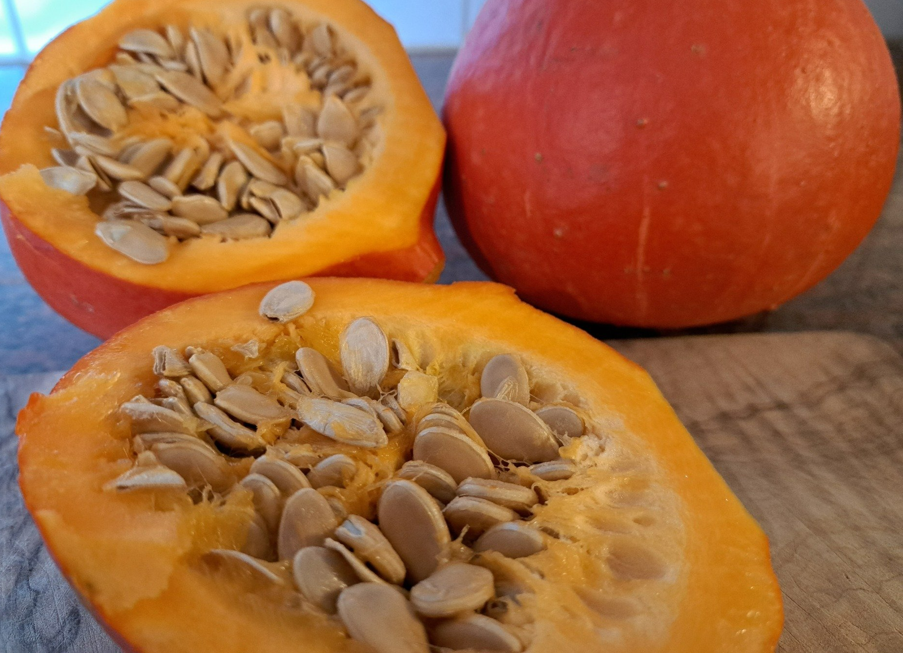 Aufgeschnittener Hokkaidokürbis mit Kernen und Fruchtfleisch