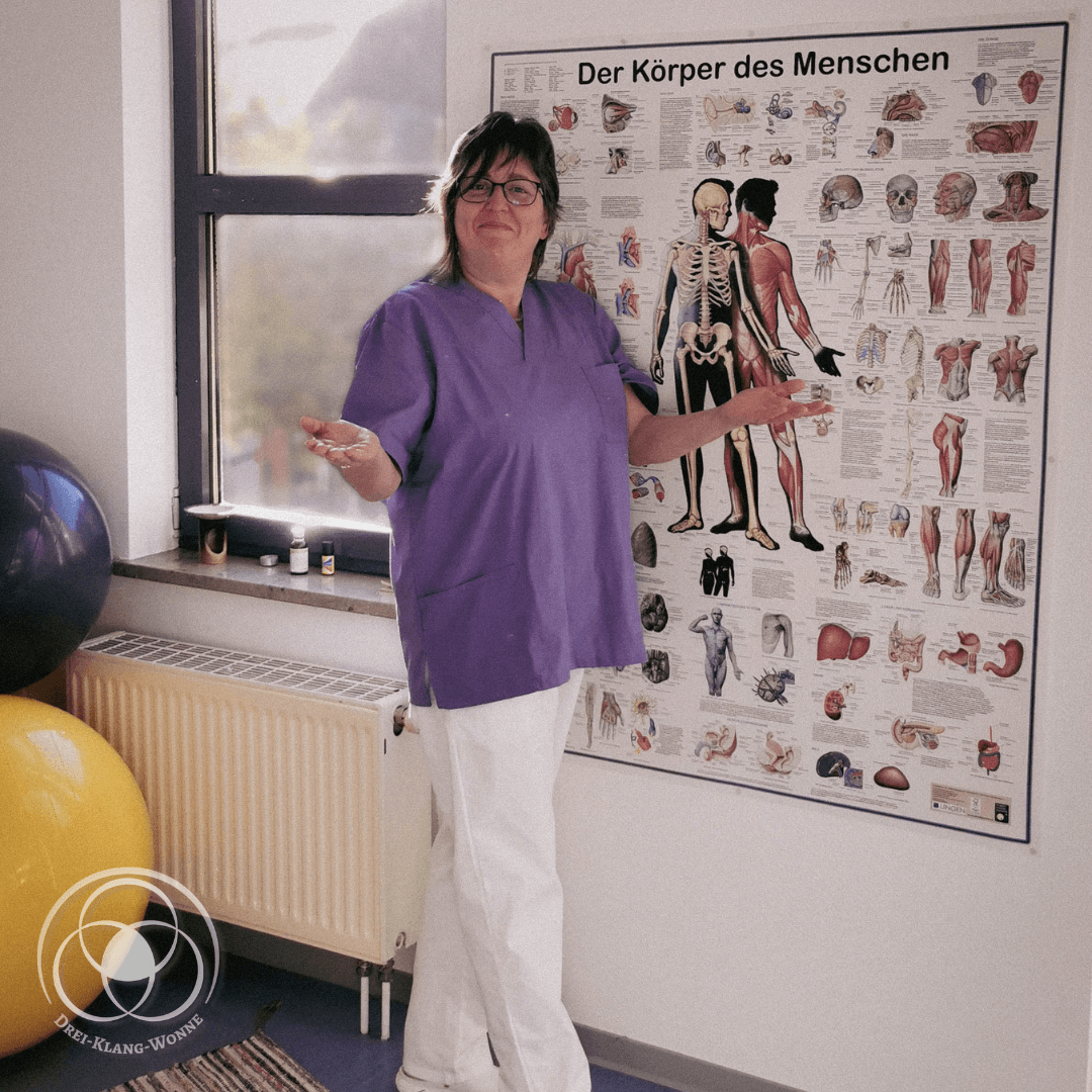 Daniela Hollands in einem Therapieraum vor einem Anatomieplakat