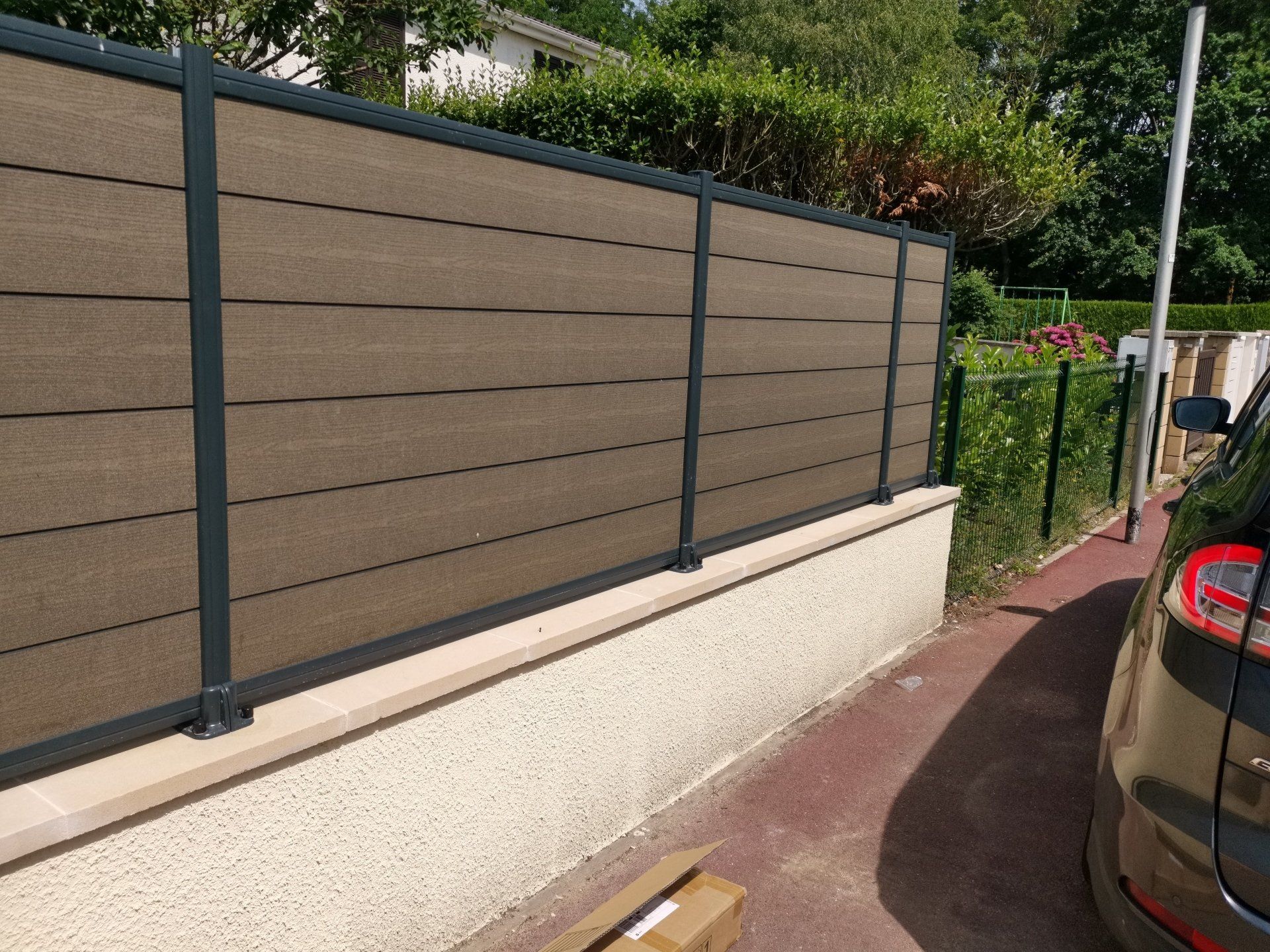 Pose de clôture en lames composites, pose des poteaux alu sur platines, création de muret avec pose de chaperons, crépis.