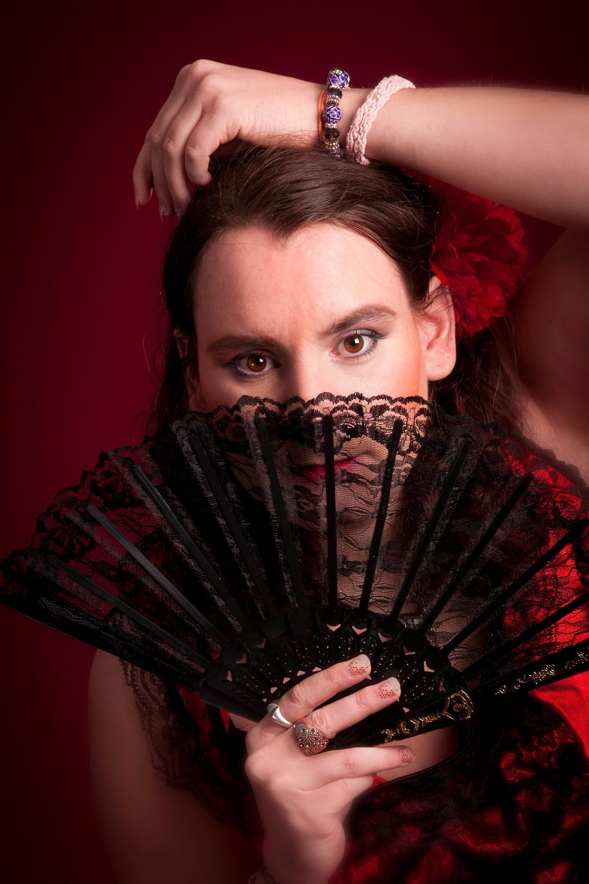 Auf diesem Bild ist eine Frau namens Carmen zu sehen, die sich als die Carmen aus einer gleichnamigen Oper verkleidet und fotografieren lassen hat. Sie trägt ein Flamenco Kleid und hält einen Fächer in der Hand.