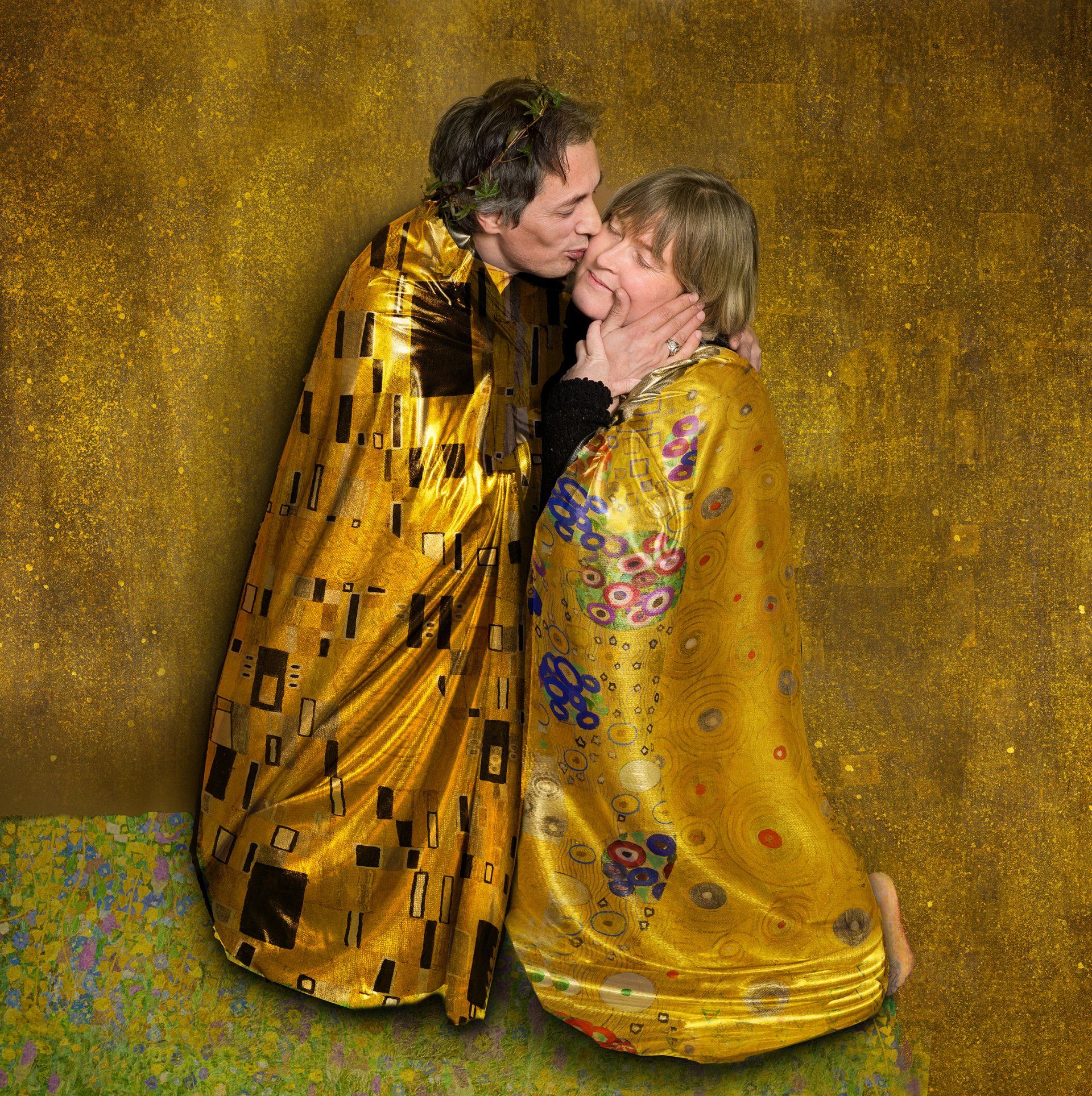 Auf diesem Foto gibt ein Mann einer Frau einen Wangenkuss. Alles ist in Gold gehalten.