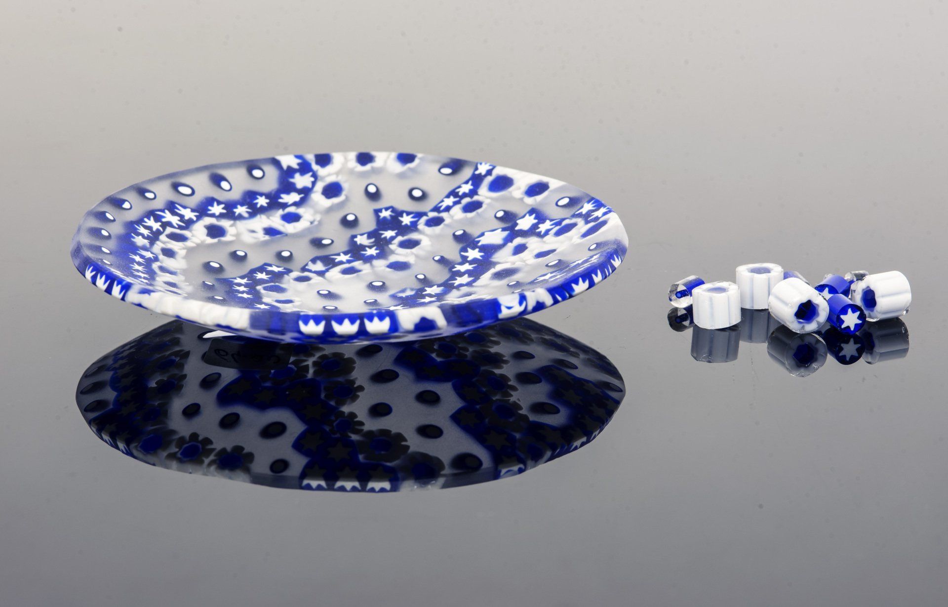 Murano glass bowl made by melting together sections of glass rods in a furnace, with each section depicting a small decorative motif. This technique is called “Millefiori Murrina Glass”Traditional decorative object typical of Murano glass processing. Artistic work made entirely by hand. The surface of these objects has a matte finish that makes it pleasant to the touch and enhances the definition of the lively colors of the Murrine. The plate is round in shape, the side is cm. 11 (4,33 inch) and is delivered in an elegant gift box.  This plate was made by me in my Murano glass studio. By purchasing an object like this you will have the opportunity to collect or give a piece of the millenary history of Venetian glass.