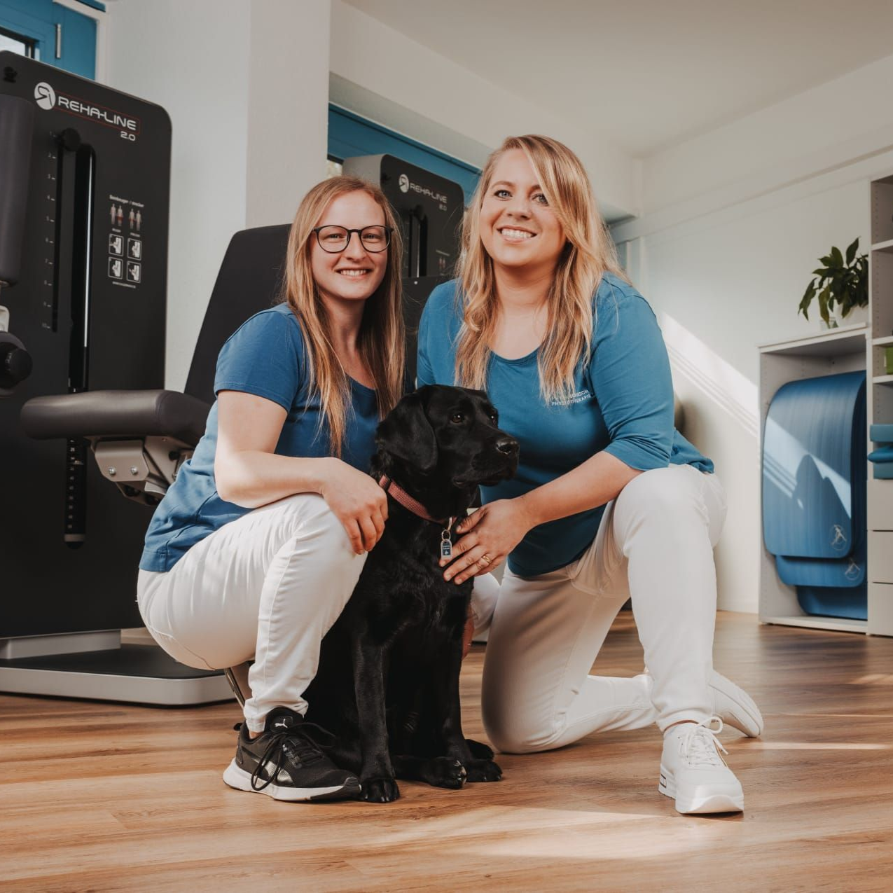 Physiotherapie Team in Erlenbach - Sarah Grötzinger und Stefanie Schmückle mit Praxishündin Tayla