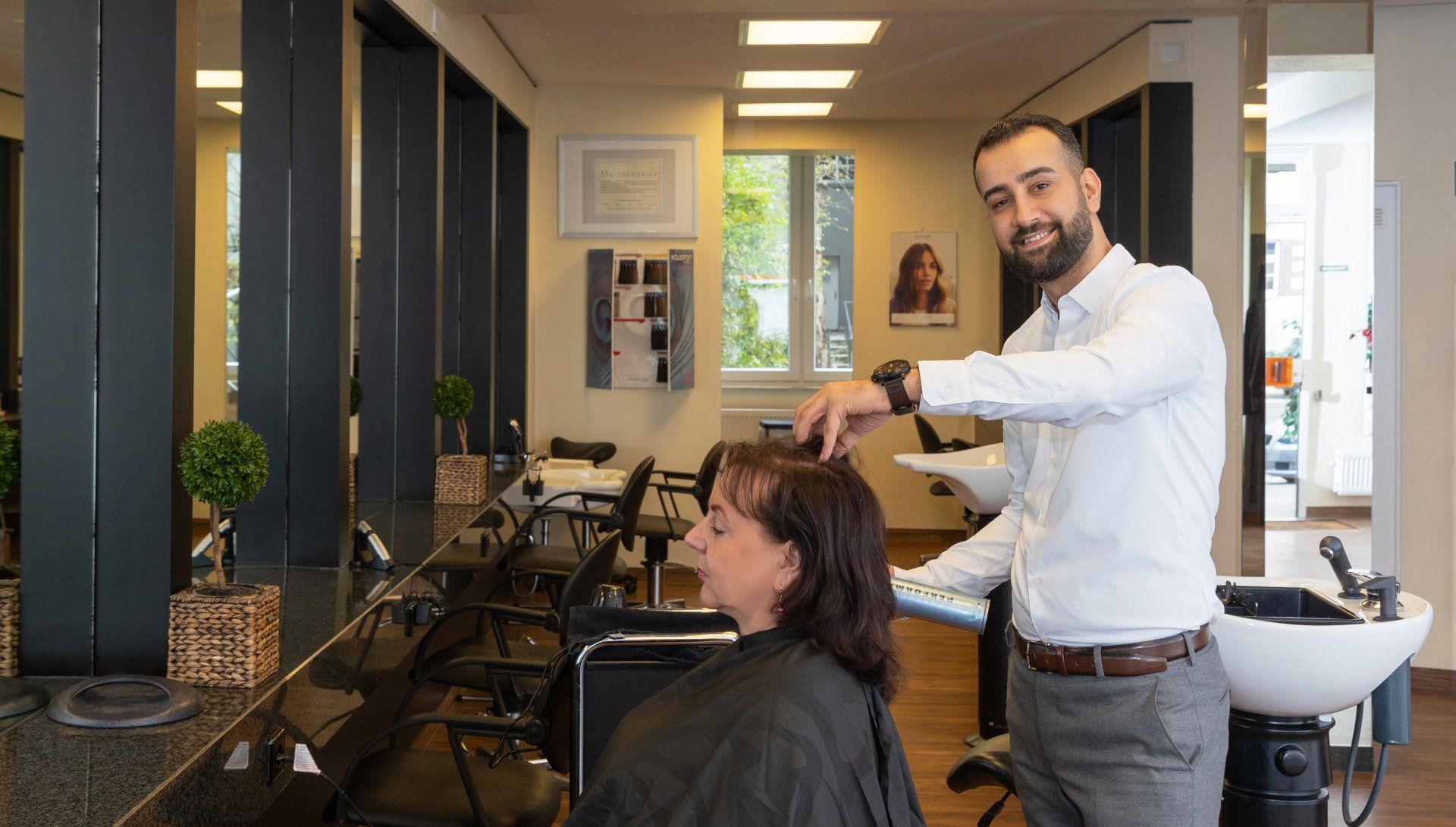Der Inhaber Maher Ahmad frisiert eine Dame