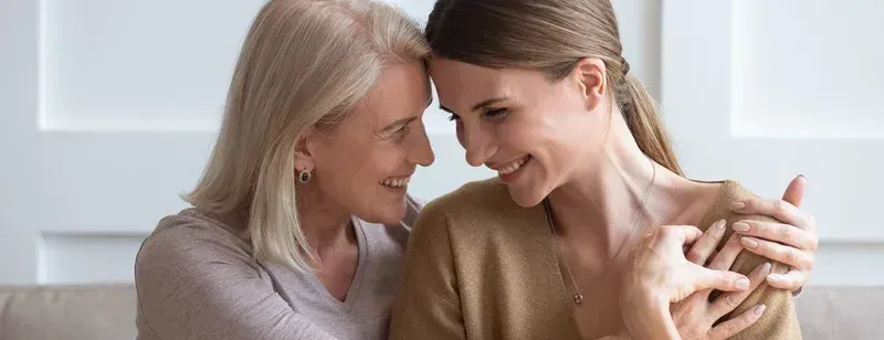 mère & fille départ de l'enfant Deux femmes souriantes se prennent dans les bras avec tendresse