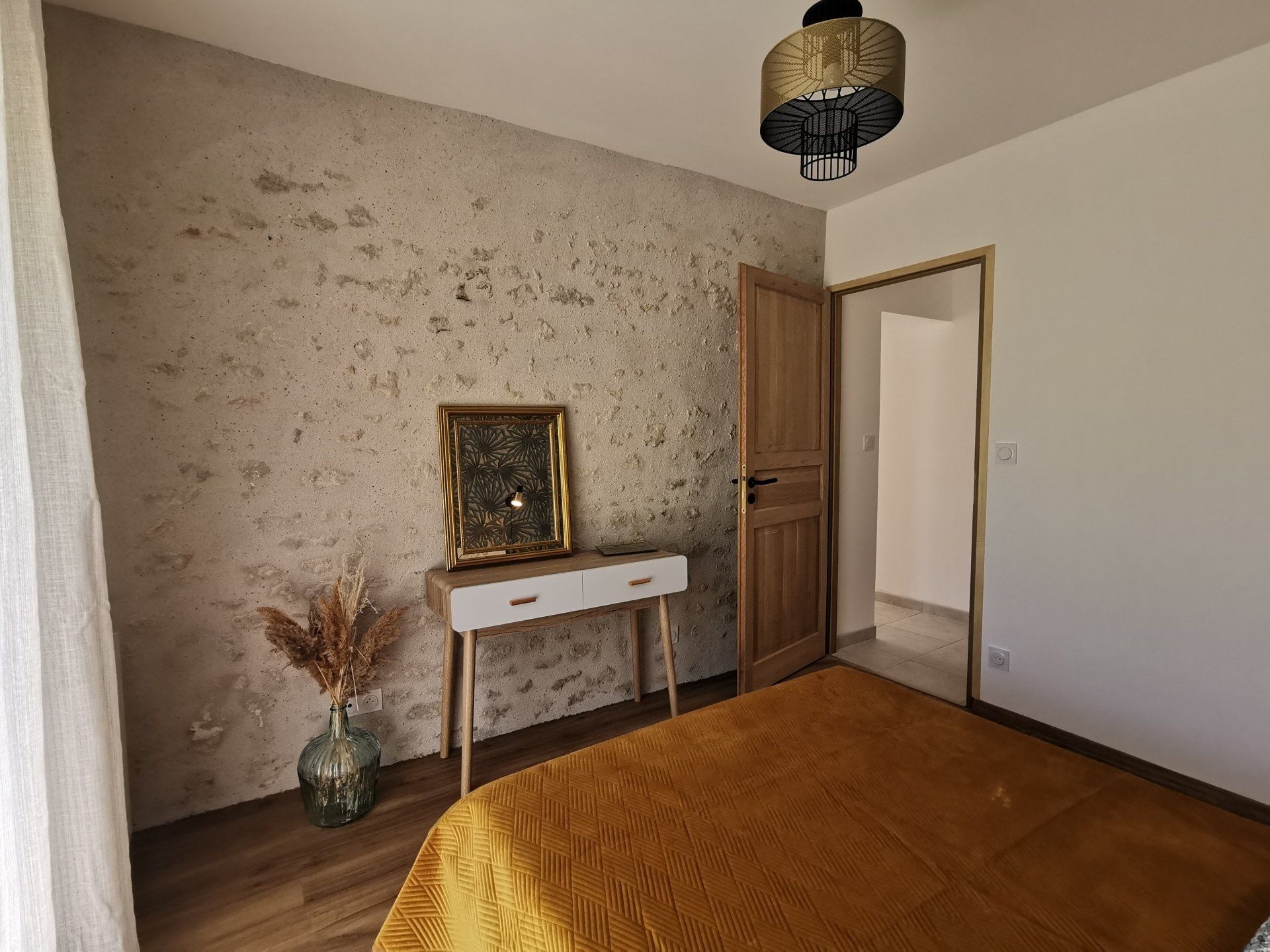 Chambre mur en pierre et poutre au plafond