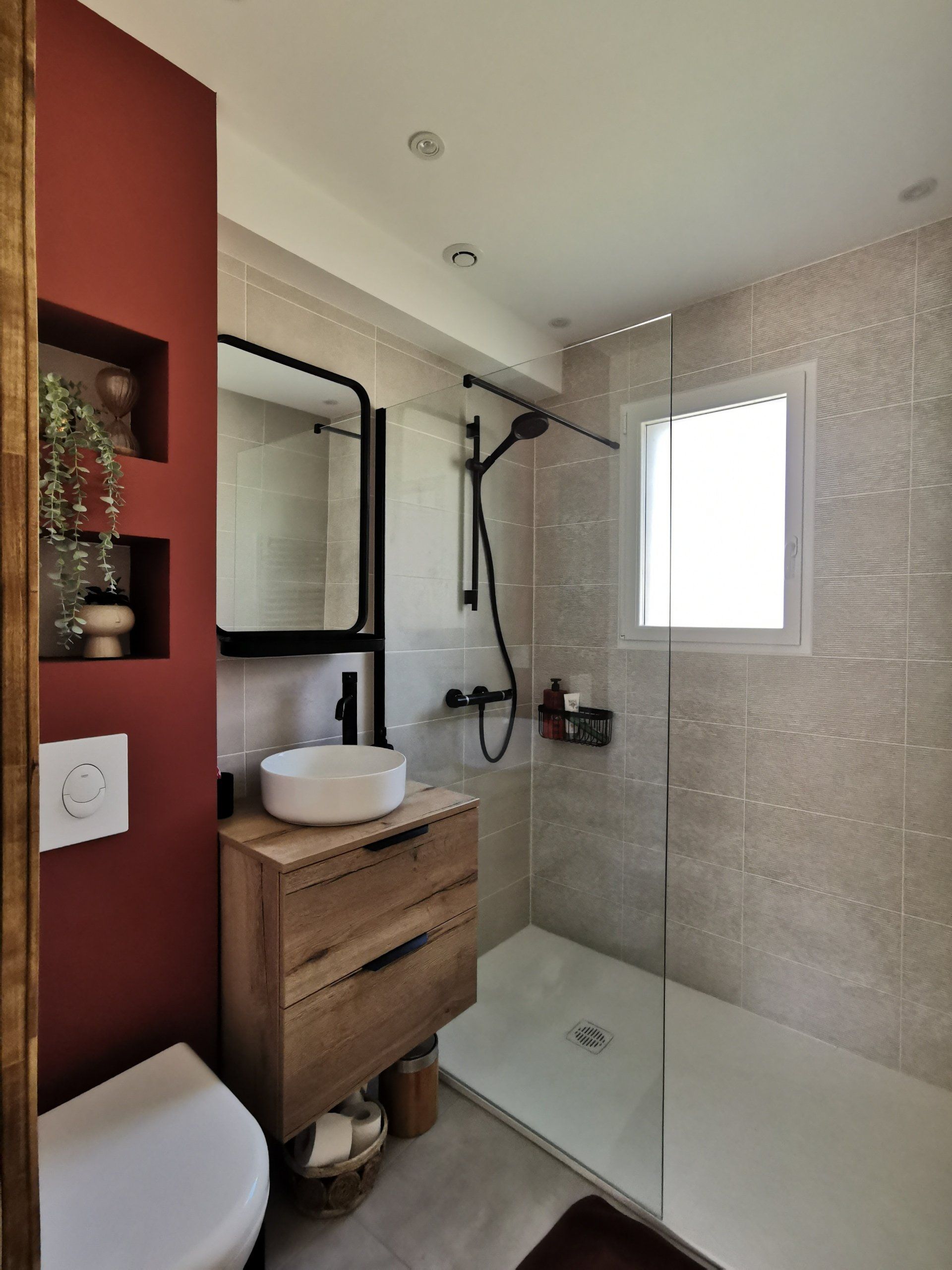 Salle de bains. Douche à l'italienne, meuble vasque bois et mur wc terracotta