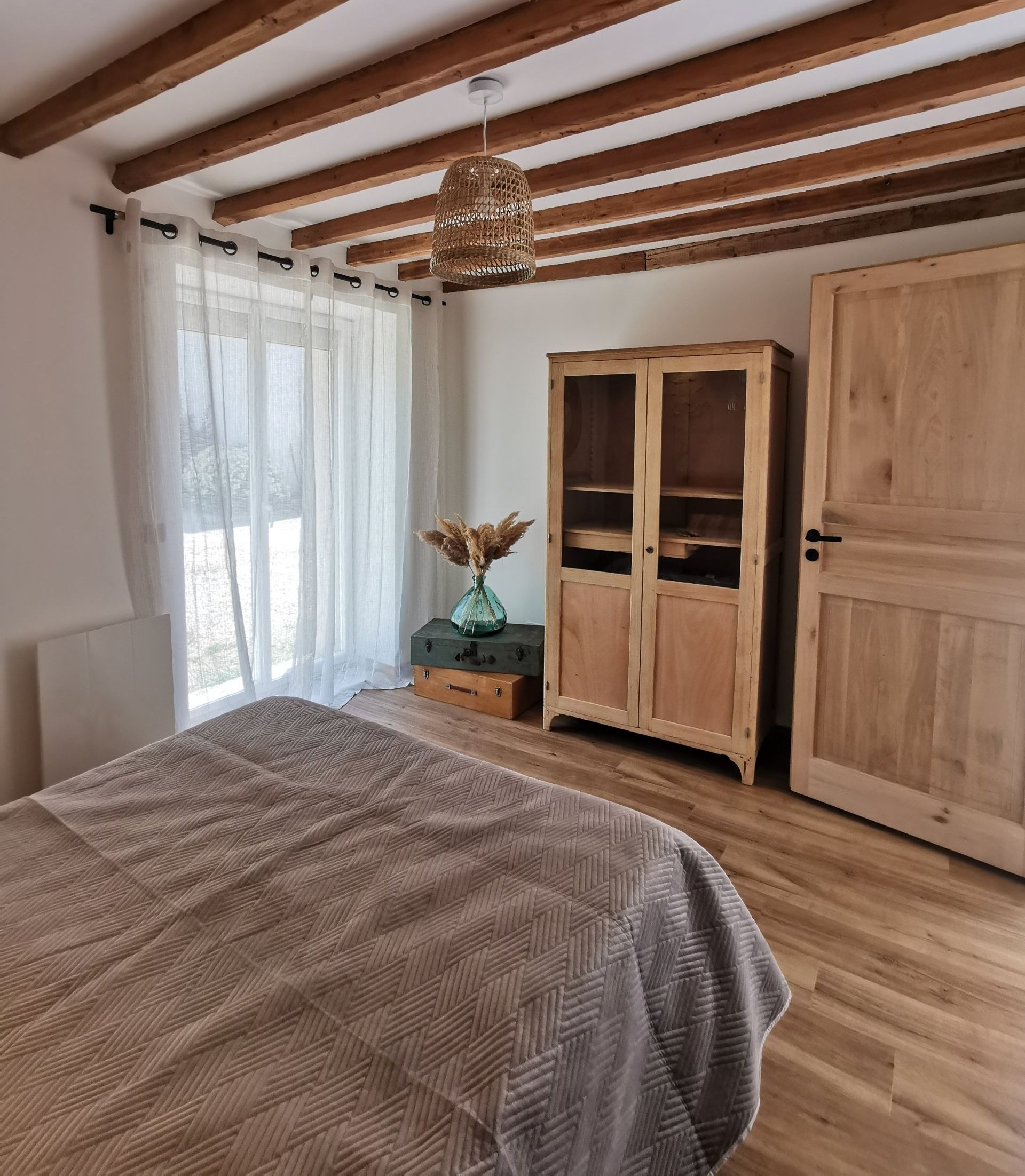 Chambre mur en pierre et poutre au plafond