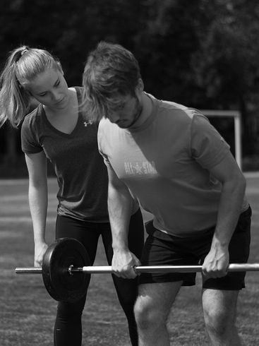Kunde führt vorgebeugtes Langhantelrudern aus