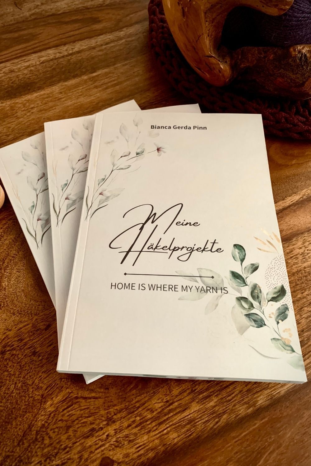 drei Buecher aufgefaechert auf Holztisch