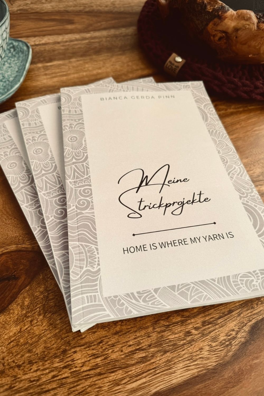 Drei Buecher "Meine Strickprojekte" auf Holztisch