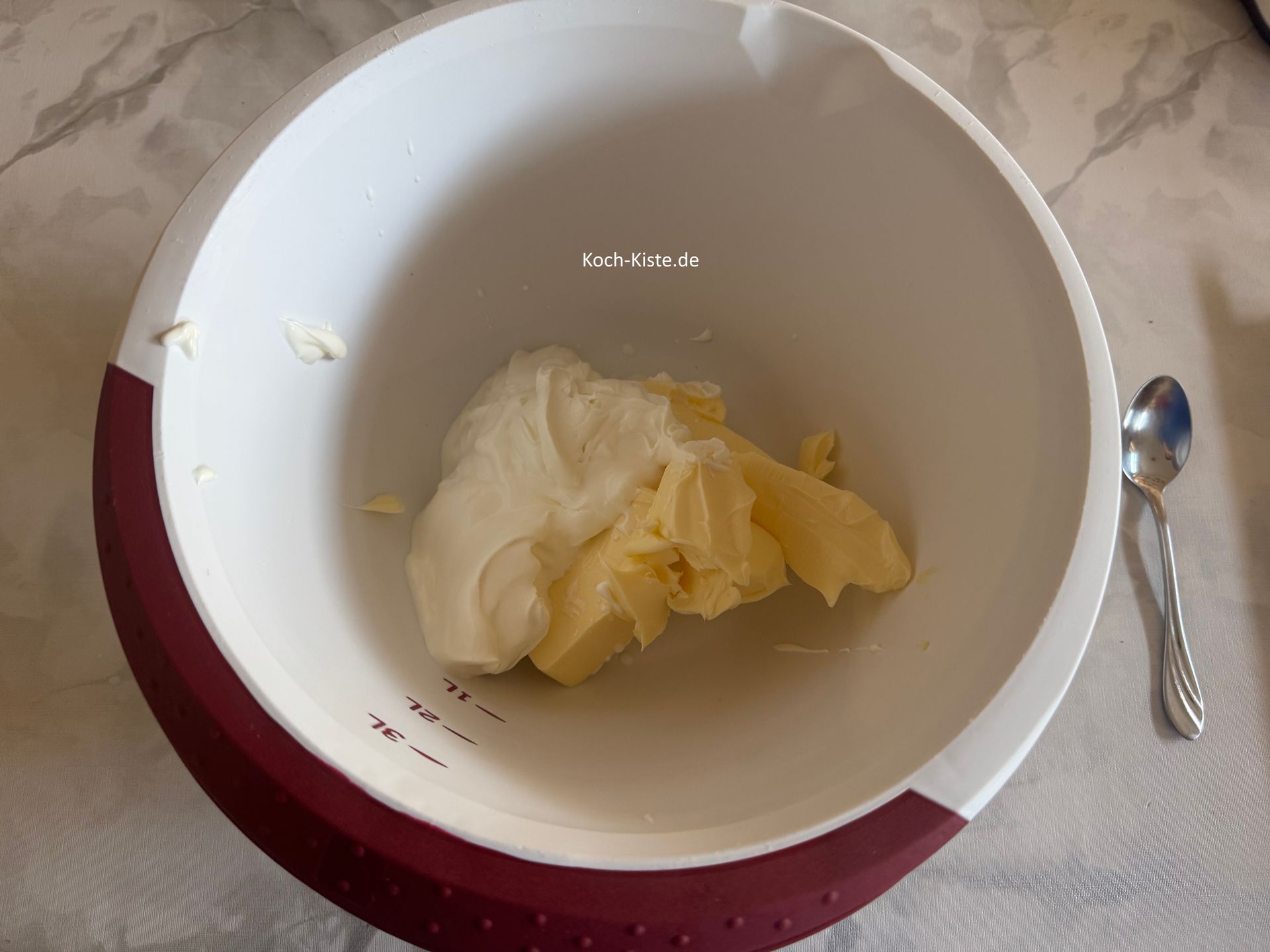 danach gebe mit Hilfe eines Teiglöffels 200 g Frischkäse mit in die Rührschüssel