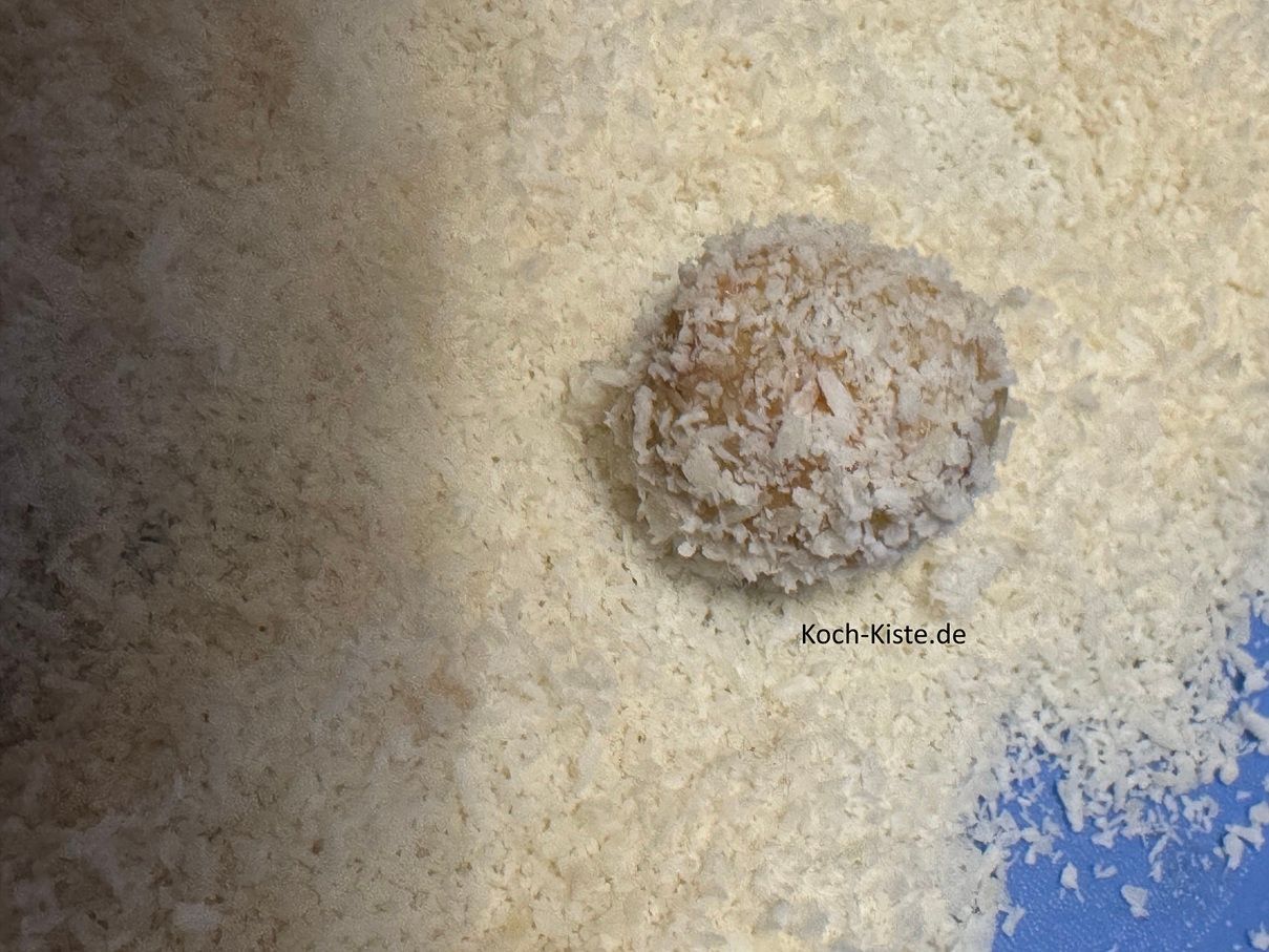 wälze die Teigkugel in Kokosraspel