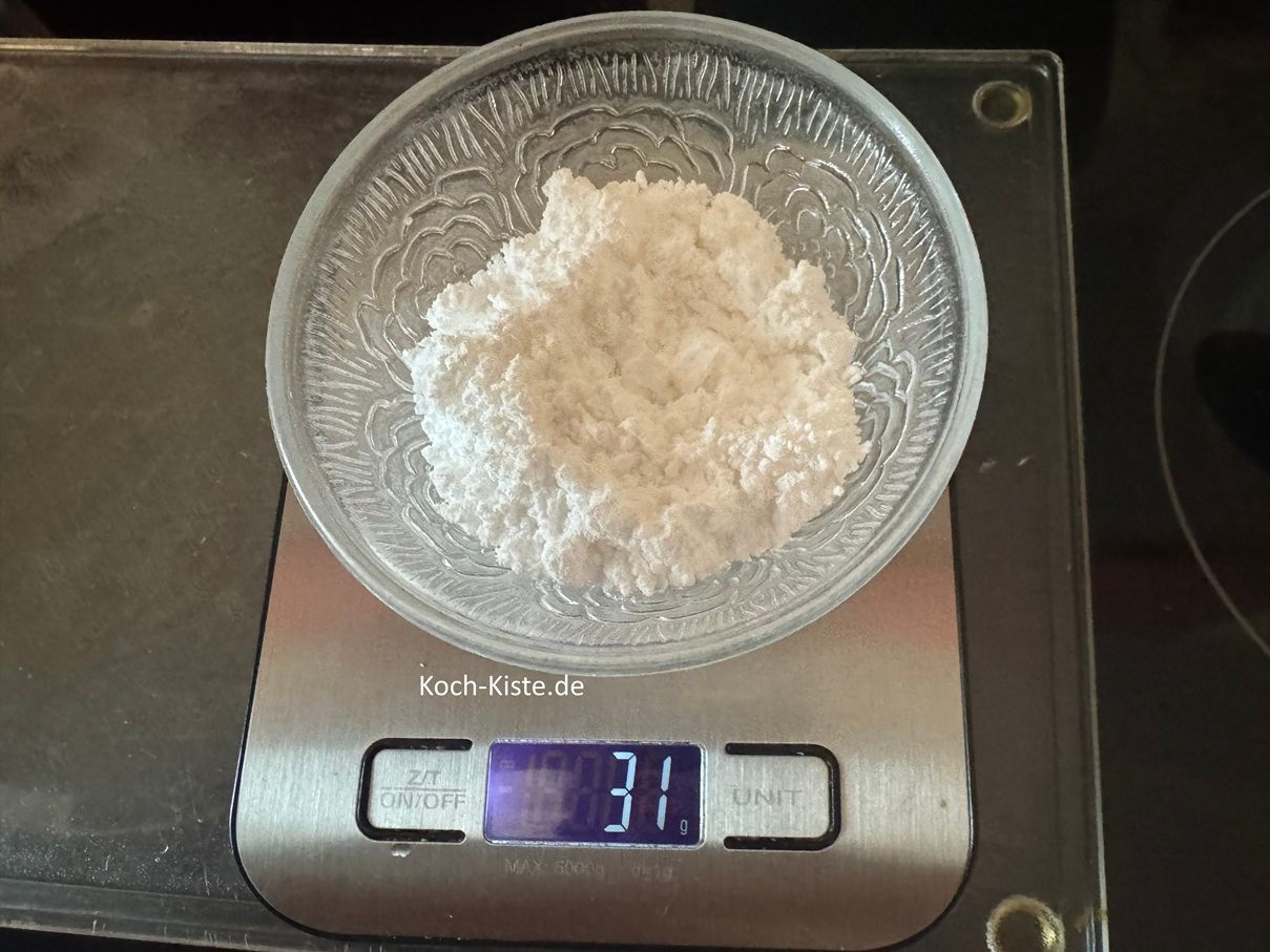 danach stelle eine kleine Schale auf die Küchewaage - auf 0 und wiege 30 g Puderzucker ab.
