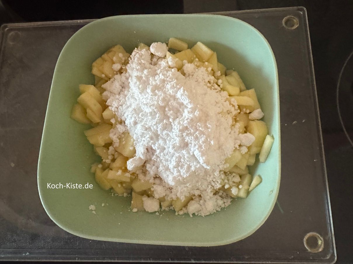 Der Puderzucker kommt zu den Apfelstücken