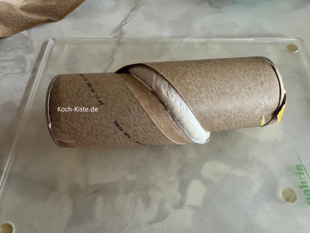 öffne an gekenzeichneter Stelle die Packung. Dann drehe die Packung , so das die Verpackung aufploppt und Du den Teig sehen kannst.