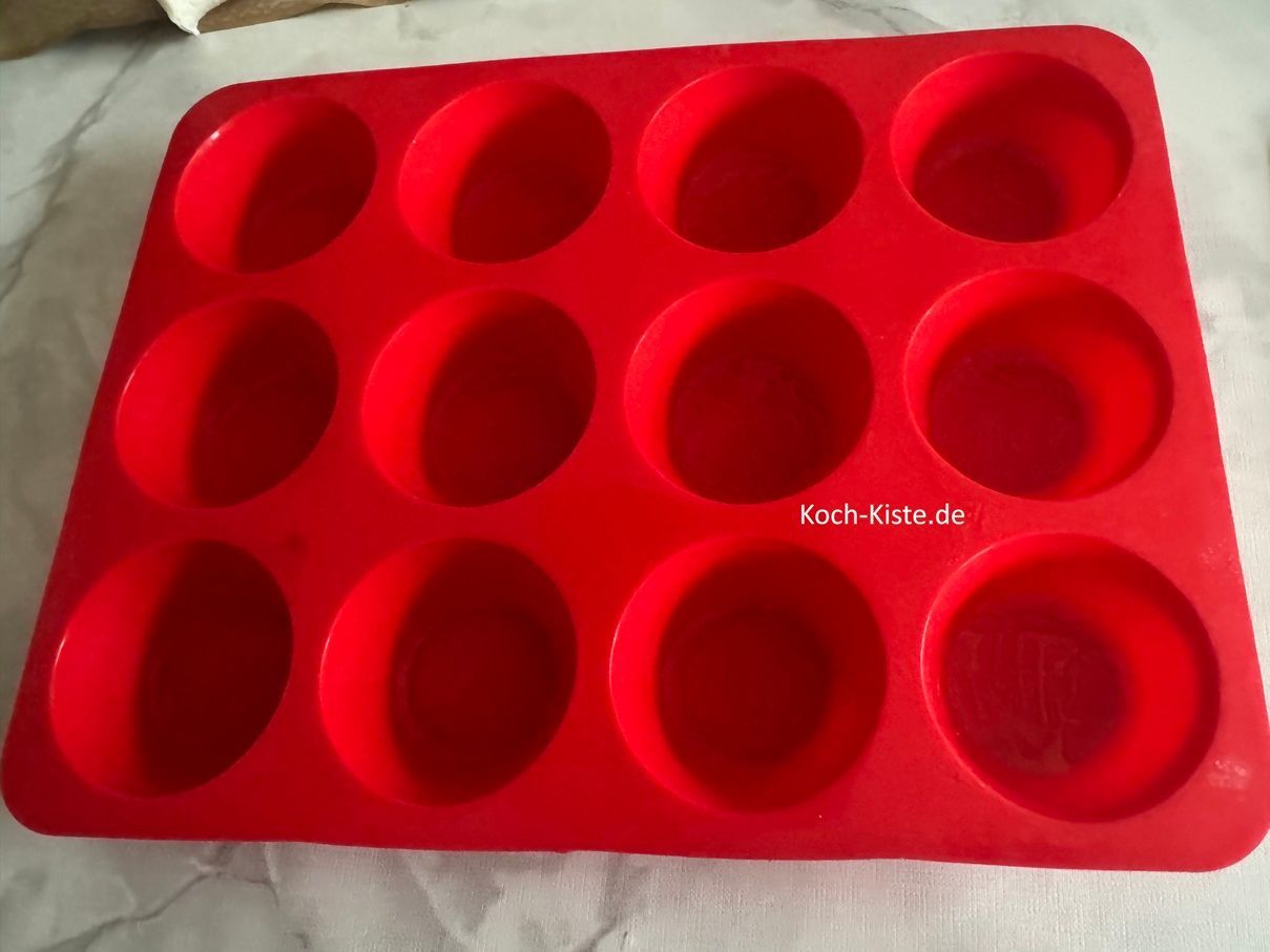 Nehme den Silikonpinsel und fette 6 Muffinmulden damit ein.